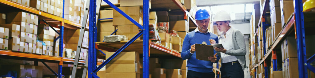 Two employees working in a warehouse using RFID tracking software to locate inventory